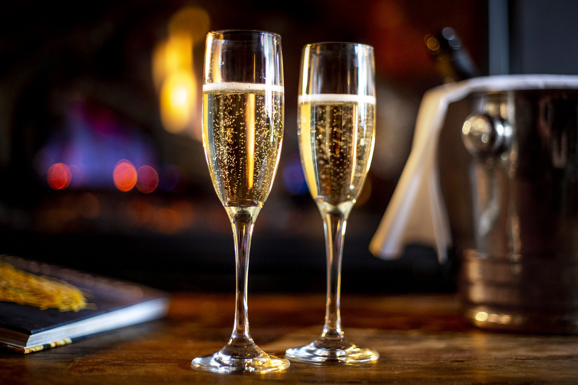 two glasses of champaign by the fire